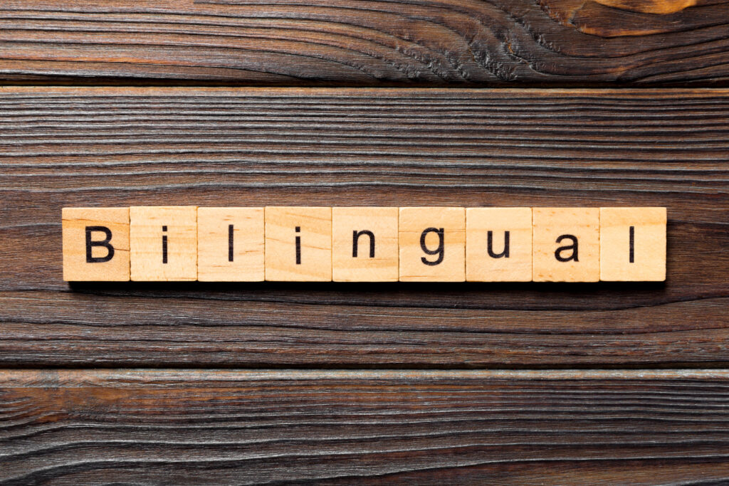 An image with scrabble tiles that spell out Bilingual on a wooden surface